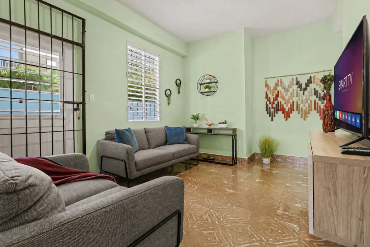 Living room with gray sofas, a smart TV and a green wall — Virelia | Colorful San Juan Escape for Four, Santurce