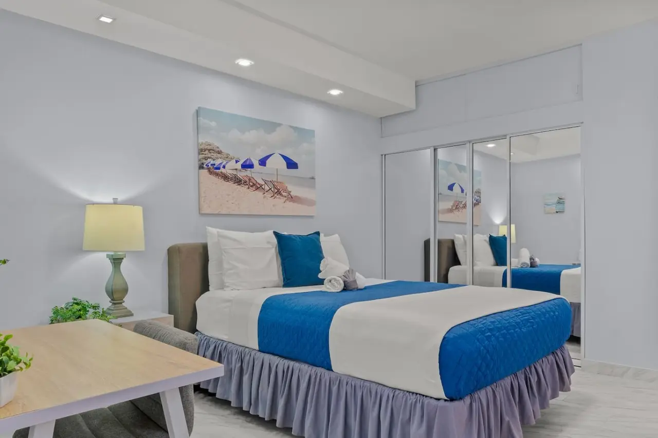 Bedroom with a blue and white bedspread — Sora | Near Airport | Patio, Parking + Laundry, Carolina