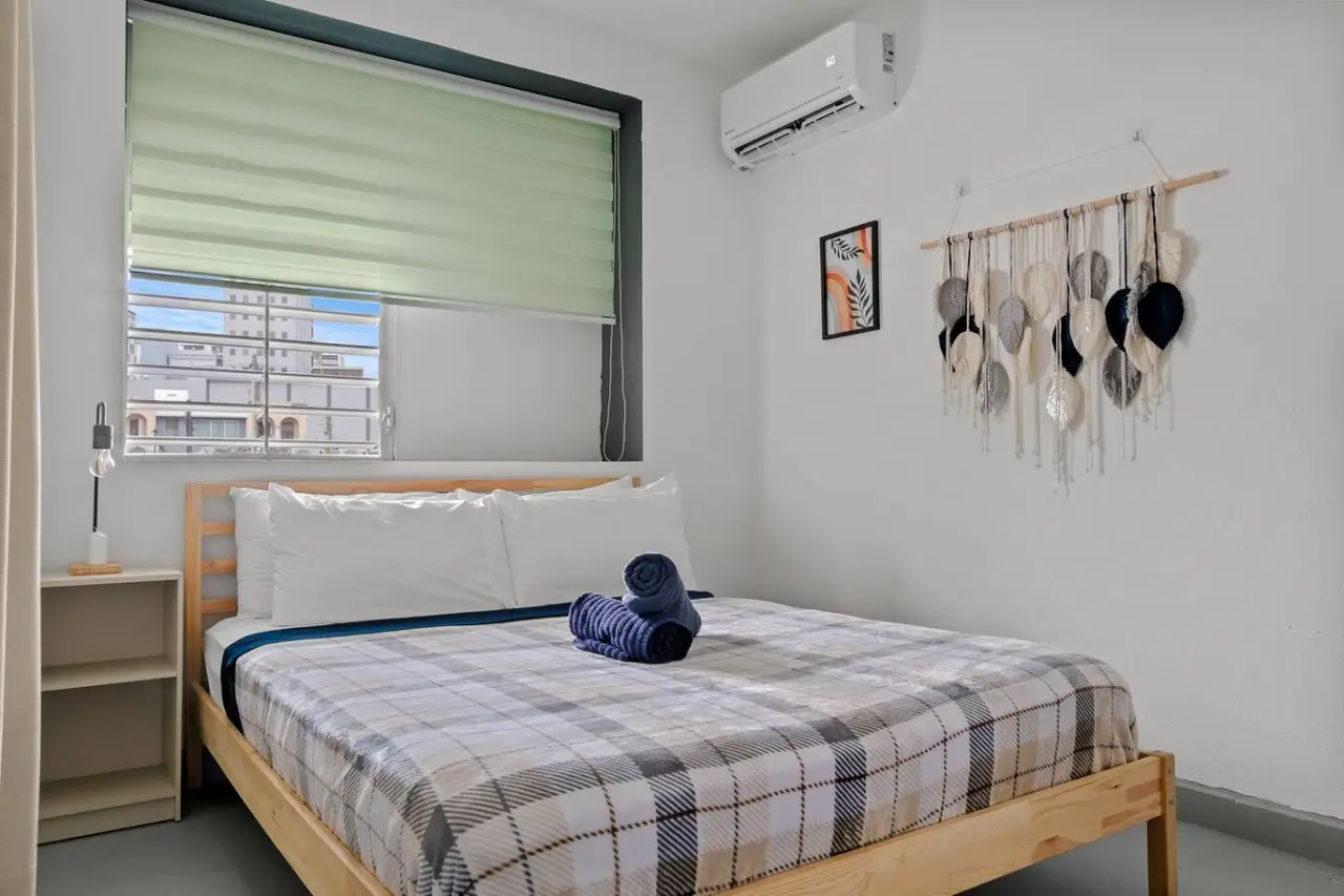 Bedroom with a bed and a blue blanket on it — Santurce Blue 2BR | Near Beach & La Placita