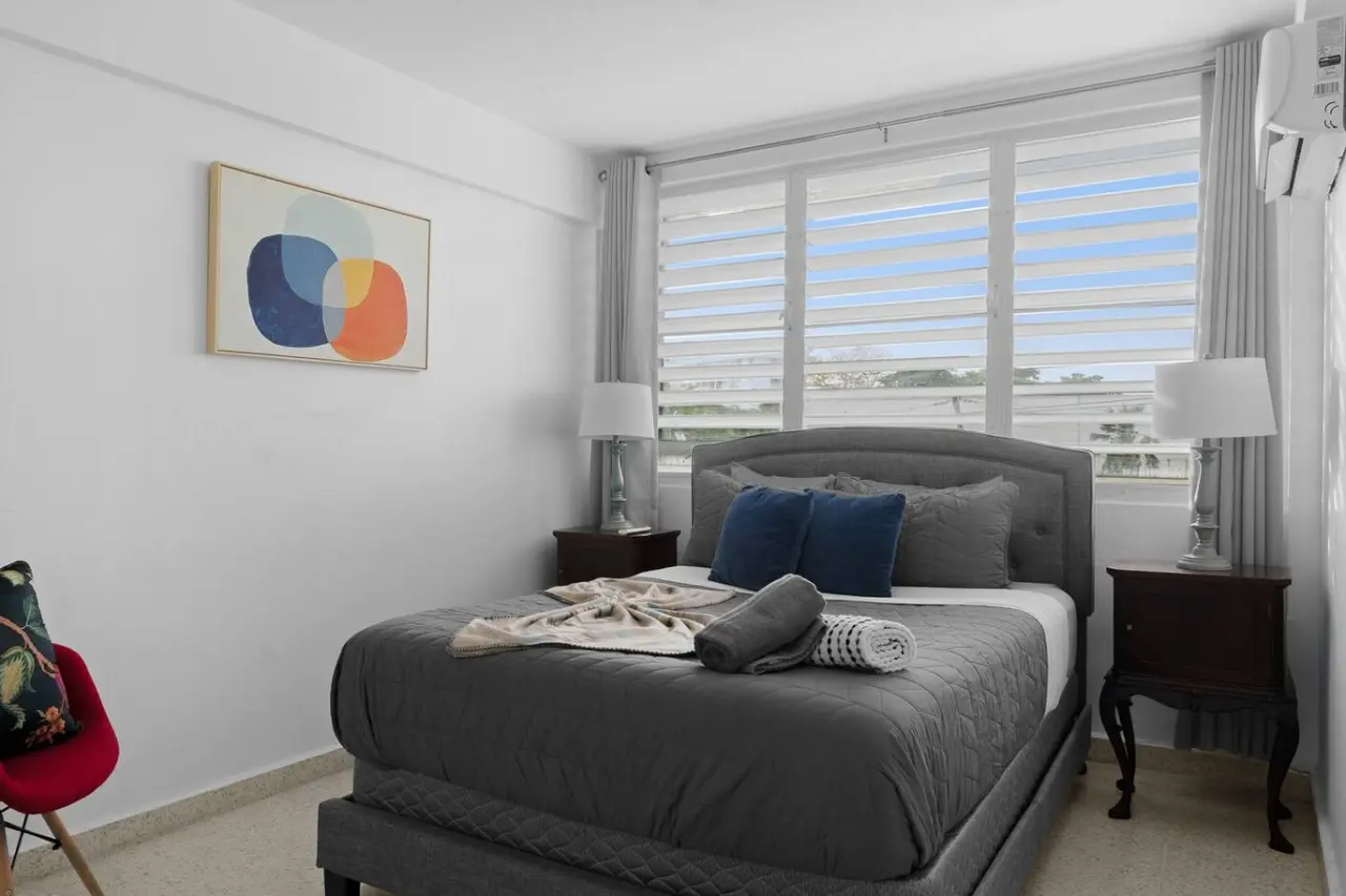 Bedroom with a bed, a lamp, and a painting on the wall — Maré 2BR | Near Ocean Park Beach + Laundry, Santurce