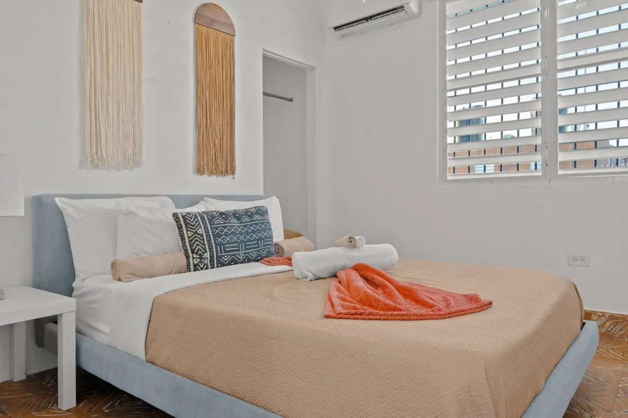 Bedroom with a bed, pillows, and a blanket — Aurelia | Three Bedrooms in the Heart of San Juan, Santurce