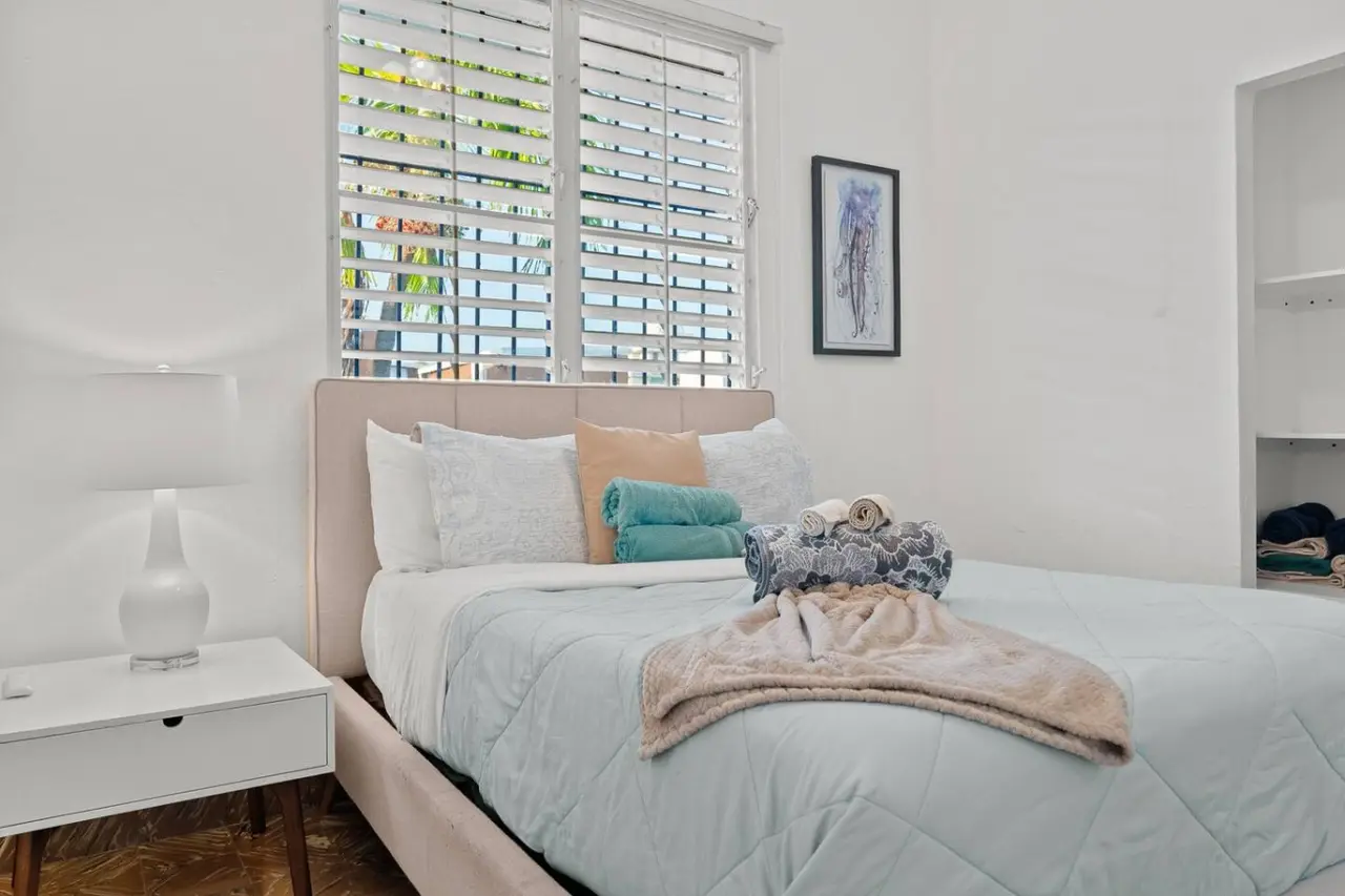 Bedroom with a queen bed, a blue-gray quilt and a white lamp — Aurelia | Three Bedrooms in the Heart of San Juan, Santurce