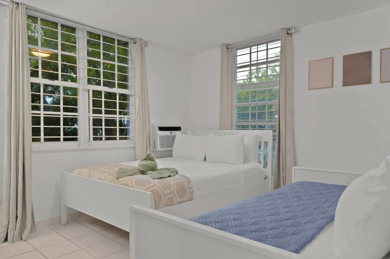 Bedroom with a white bed and a window with curtains — San Juan 2BR | Sleeps 7 + Balcony & Laundry, Santurce