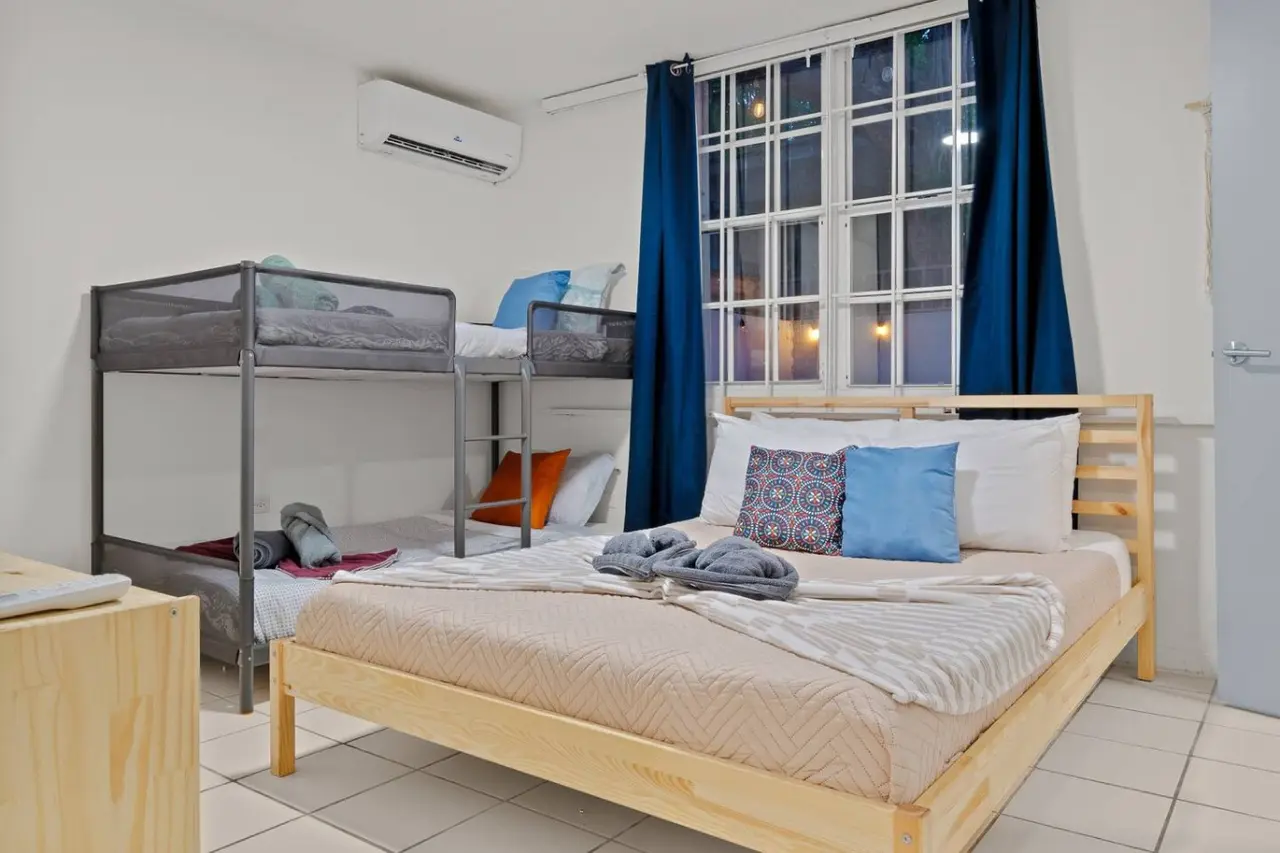 Bedroom with a bunk bed and a blue pillow on the bottom bunk — The Castillo | Sleeps 8 | 2BR + Backyard & Parking, Santurce